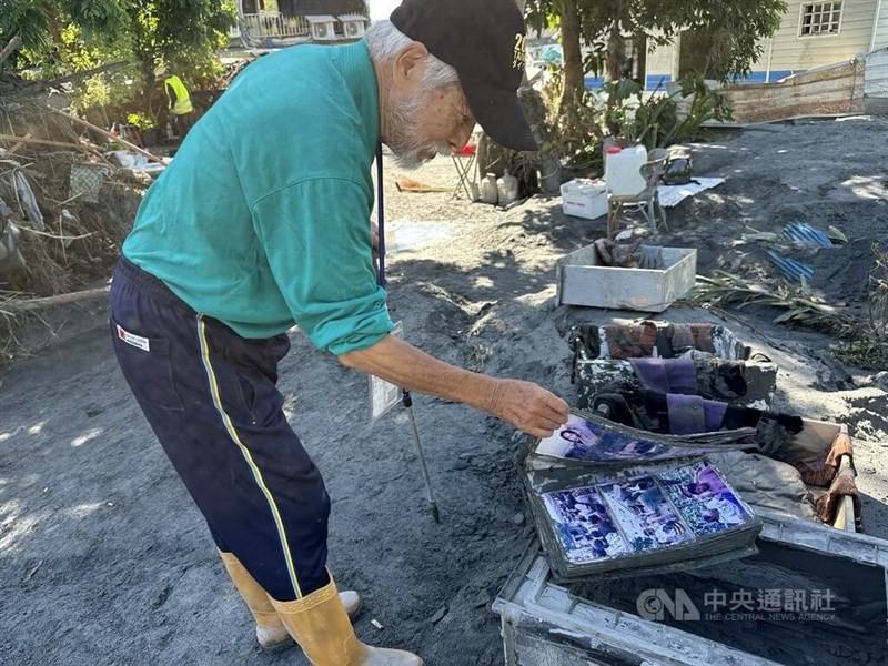 Local author Hawk Rumaling checks his books after massive floods in Hualien County. CNA photo Sept. 29, 2025