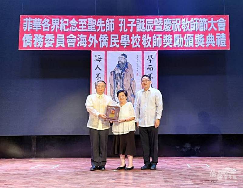 大使周民淦（左）頒贈獎座給執教50年的資深優良教師嘉南中學副校長
許麗玲（中），菲華文教服務中心主任莊博智（右）同臺見證