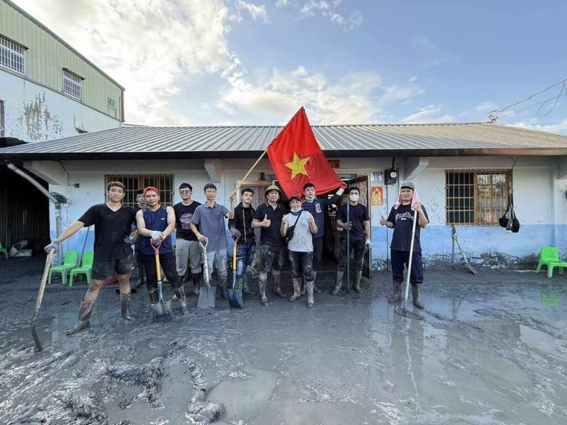 越南移工扛著越南國旗，穿梭在花蓮光復因大淹水而滿目瘡痍的泥濘街道，在3天時間內共清理6戶，速度之快，令當地人驚訝。（馮畹芝提供）