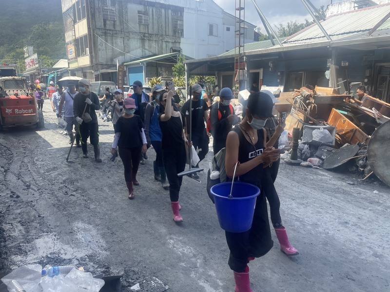 Volunteers traverse around Hualien County's Guangfu Township with buckets and shovels to help clear the area on Saturday. CNA photo Sept. 27, 2025