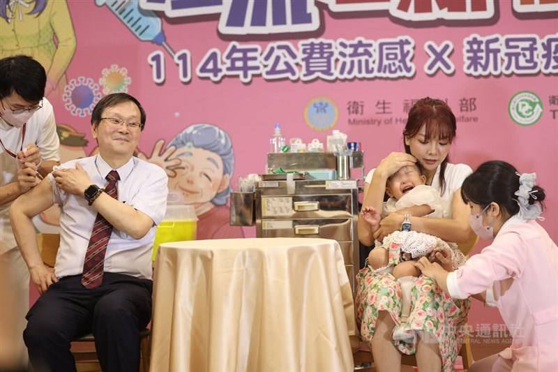 Taiwan Centers for Disease Control Director-General Chuang Jen-hsiang (second left) is vaccinated with a child in a press event in Taipei on Wednesday. CNA photo Oct. 1, 2025