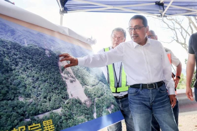 新北市雙溪區北38線大規模崩塌，中央補助經費後，完成首階段復建工程，市長侯友宜（前）2日視察指出，該處上方仍有台電設施及廢棄物，市府已協調台電清除，以免成為新的安全隱憂。（新北市府新聞局提供）