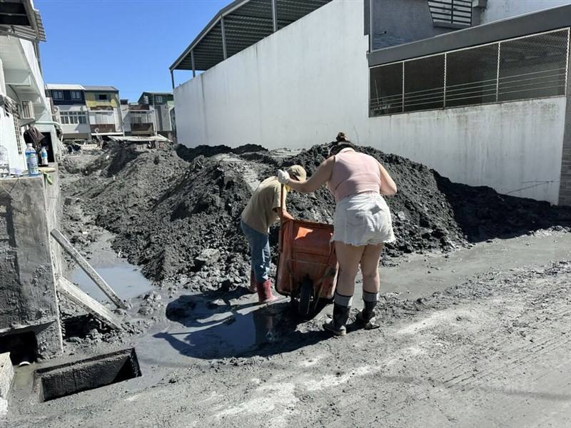 People clean up mud and soil from the recent flooding on the streets of Hualien County's Guangfu Township on Sunday. CNA photo Oct. 5, 2025