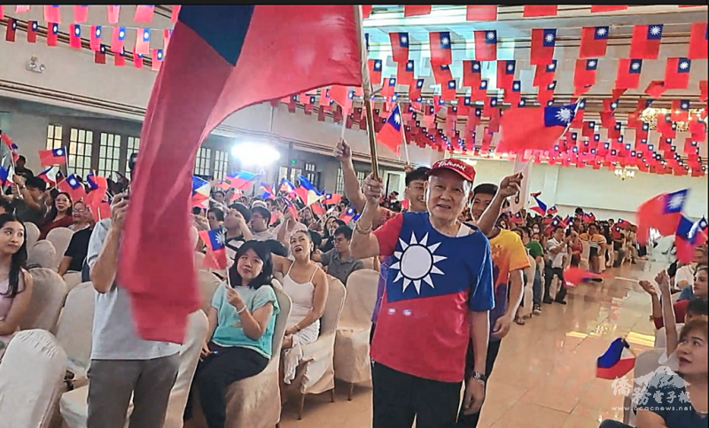 納卯菲華文化協會常務委員王守慶帶領所有僑胞繞場一周振奮僑心