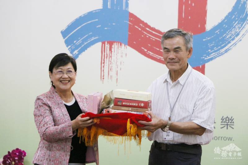 徐佳青與首位報到僑胞廖貴興合影，頒發紀念品