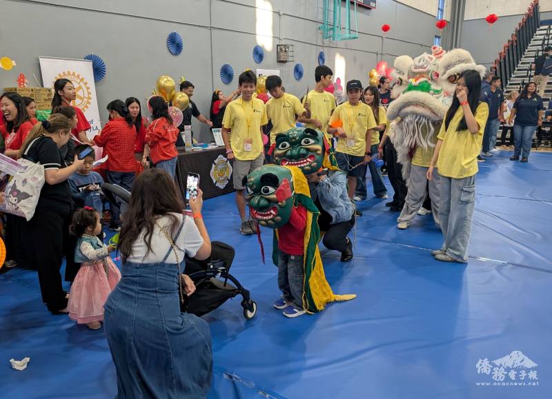 許多參觀者現場學舞獅，也爭相戴上獅頭照相留念