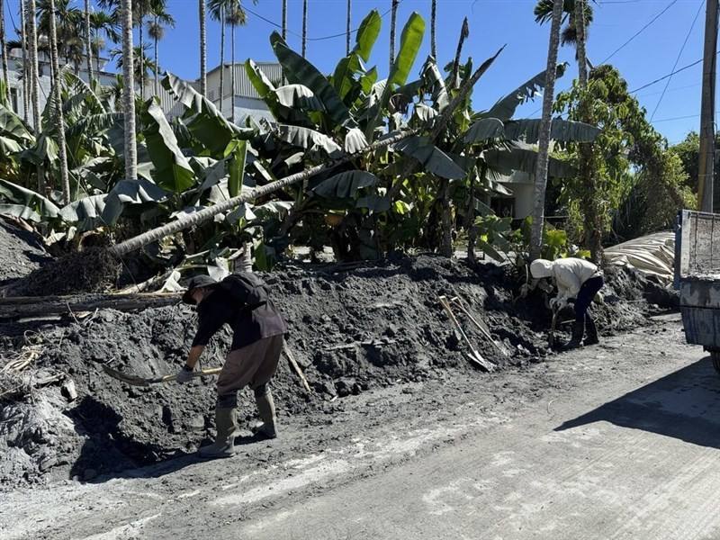 Volunteers shovel mud by a road in Guangfu Township, Hualien County, on Sunday. CNA photo Oct. 5, 2025
