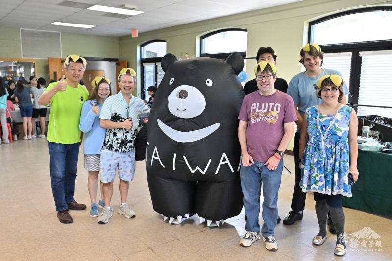 洛麗臺灣華語文學習中心學生們頭戴柚子瓜皮帽與臺灣黑熊人偶合影