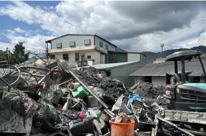 A house stands behind piles of debris in Guangfu Township, Hualien County, on Monday. CNA photo Oct. 6, 2025
