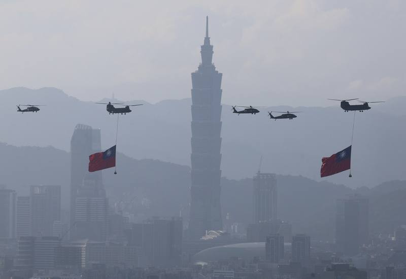 國軍8日上午進行空中全兵力預演，國旗機隊吊掛巨幅國旗飛越台北101大樓前，場面壯觀。