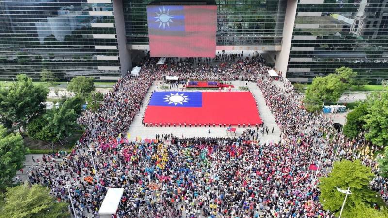 台中市政府10日舉行國慶升旗典禮，由76名民防義警及霹靂小組聯手展護長36公尺、寬24公尺的巨幅國旗進場。（台中市政府提供）