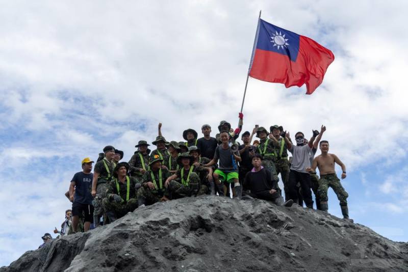 救災志工們揮舞國旗，並邀請官兵共同慶祝國慶日。（軍聞社記者蔡枋澐攝）