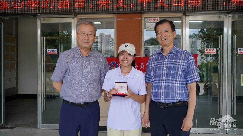 漢城華僑中學校長于植盛（左）及顧問梁兆林（右）頒發感謝牌予教導民俗體育的老師冉茂萍