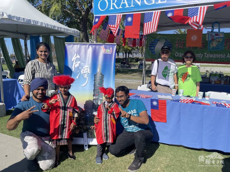 總統府國策顧問林榮松(後排右2)參觀臺灣文化攤位，欣見其他族裔小朋友穿上臺灣原住民服裝拍照留念。圖後排右1為僑務顧問張欣珠。