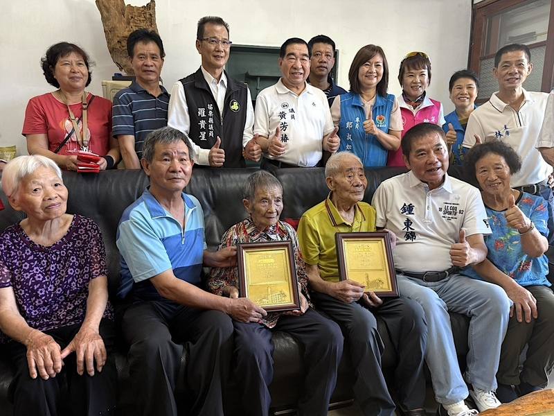 重陽敬老，苗栗縣長鍾東錦（前右2）14日前往三義鄉慰訪縣內唯一百歲人瑞夫妻檔鍾新龍（前右3）、鍾林玉英（前左3），送上縣府敬老禮金、禮盒，並轉贈總統府敬老狀和衛福部金鎖片，祝福老人家長命富貴