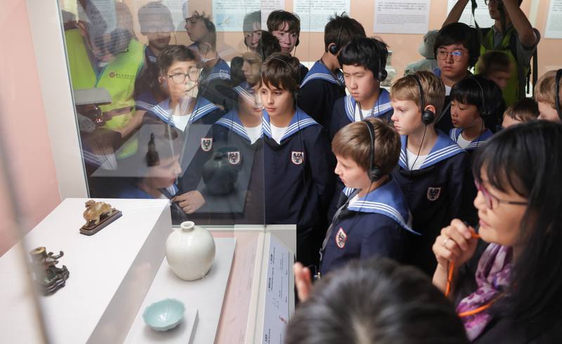 來自奧地利的國寶維也納少年合唱團15日至國立故宮博物院參觀，仔細聆聽導覽員解說介紹。