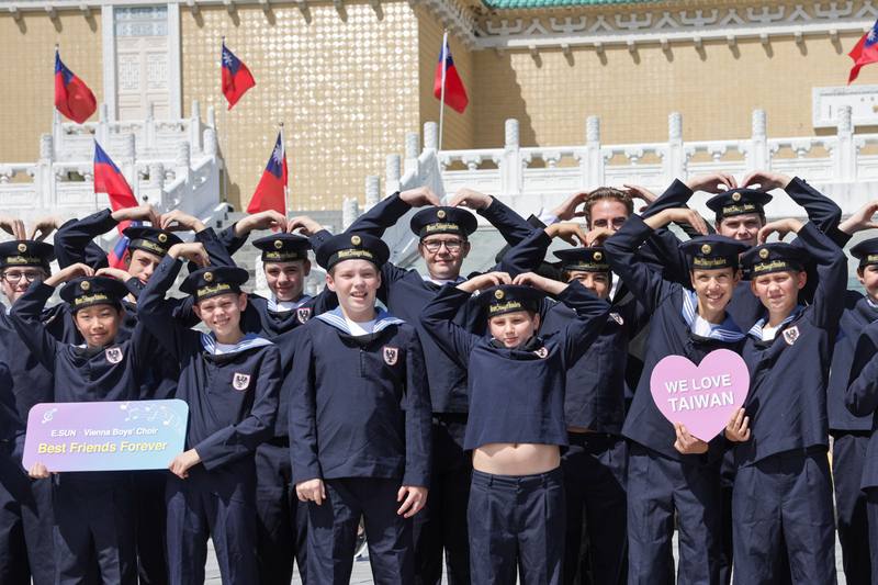 來自奧地利的國寶維也納少年合唱團15日至國立故宮博物院參觀，手比愛心開心合影留念。