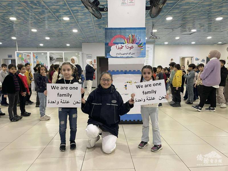 滿納海學校學生手舉「We are one family」標語，象徵跨國友情與教育相連的深厚情誼