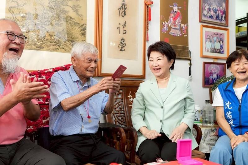 重陽節即將到來，台中市長盧秀燕（右2）17日前往北屯區探訪百歲人瑞劉百忠（左2），致贈台中市重陽敬老禮金新台幣1萬元，並轉贈中央的重陽賀禮金鎖片。（台中市政府提供）