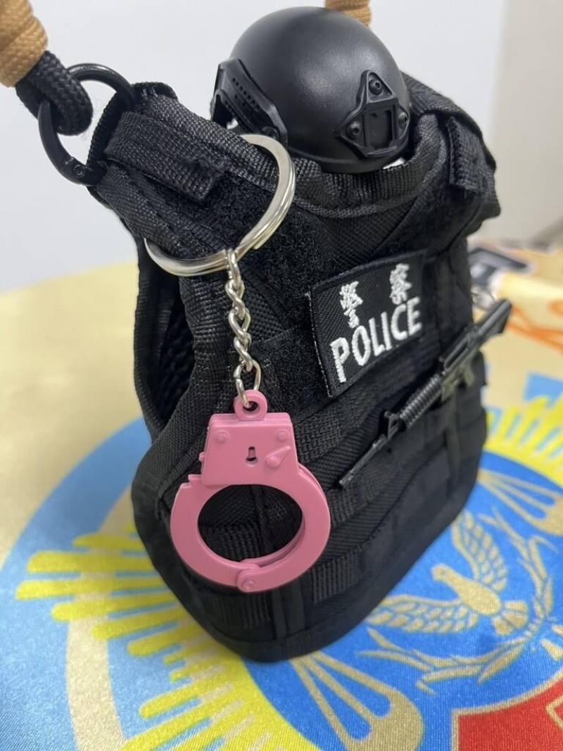 韓國女團BLACKPINK週末將在高雄開唱，小港警分局藉「粉紅旋風」宣導防詐推出抽獎活動，吸引民眾互動學習，還能抽附贈粉紅小手銬吊飾的警用防彈背心造型小杯套。（高雄市小港警分局提供）