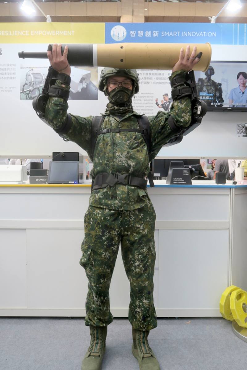 中科院16日於台灣創新技術博覽會展出軍用外骨骼系統，由研發人員穿戴軍用動力上肢外骨骼，輕鬆舉起20公斤重的105公厘戰車砲彈模型