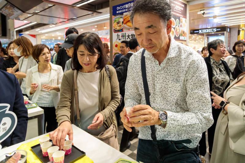 嘉義縣11家咖啡莊園業者18日起在日本大阪近鐵百貨設置專區，展售產自阿里山區的精選精品，咖啡的香氣吸引人潮來試飲。（嘉義縣政府提供）