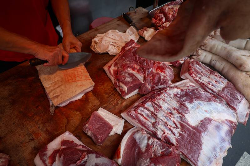 圖為新北市樹林區傳統市場一處豬肉攤，攤商正整理肉品。