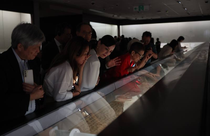 Visitors to the National Palace Museum lean toward shelves displaying relics in the exhibition "An Assembly for the Ages: The Legend of the Northern Song Elegant Gathering in the Western Garden" in Taipei on Tuesday. CNA photo Oct. 21, 2025
