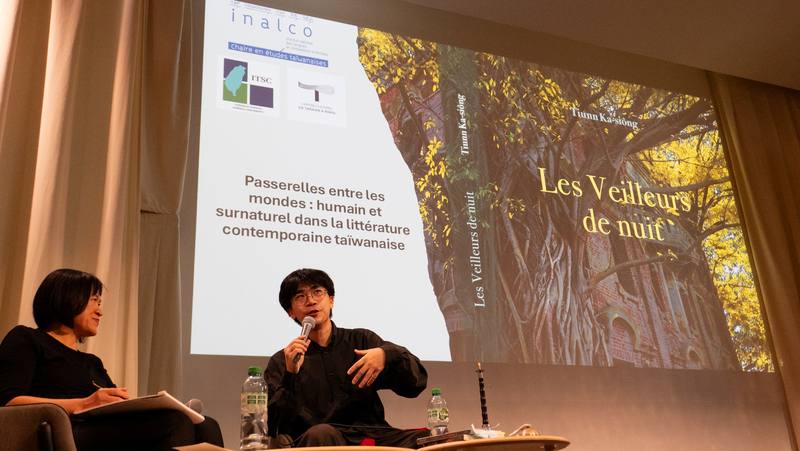 台灣小說「夜官巡場」以嘉義民雄鬼屋為故事起點，揉合二二八事件邊緣野史，10月由法國「亞洲館」出版社推出法文譯版。作家張嘉祥（右）20日受邀至巴黎分享創作理念，投影畫面為該書封民雄鬼屋。