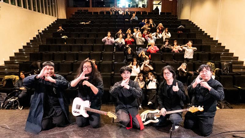 作家張嘉祥首部小說「夜官巡場」法文版問世，他與其所屬樂團「裝咖人」20日在巴黎，出席「跨界橋樑：台灣當代文學中的人類與超自然現象」活動，宣傳新書，眾人以手勢比「台」字合影。