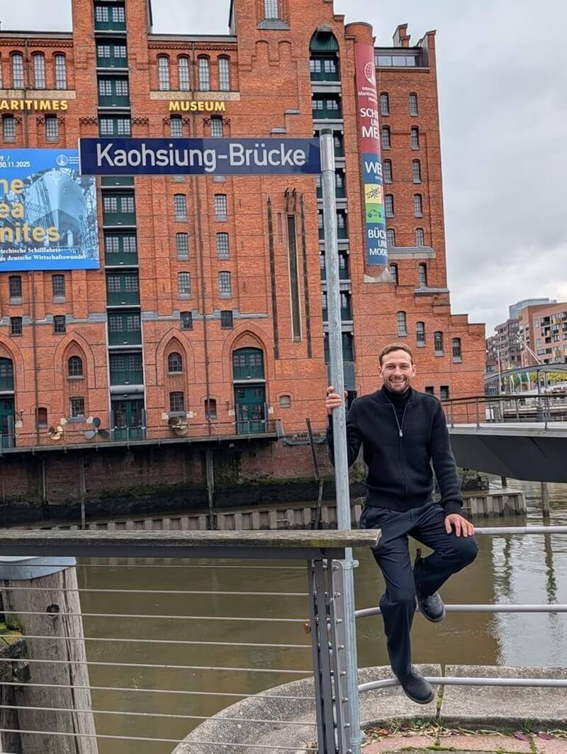 德國漢堡自民黨籍區議員費雪主導推動「高雄橋」命名案，盼讓台灣與德國之間的民主夥伴關係在城市日常中具象可見。掛牌後費雪第一時間開心與高雄橋合照。（費雪提供）