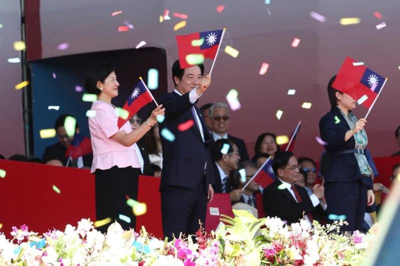 總統賴清德（前左2）與夫人吳玫如（前左）在114年國慶大會上揮舞國旗。（中央社檔案照片）