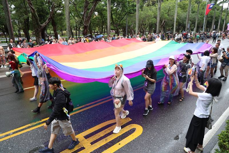 People carry a giant rainbow flag while marching through the streets of Taipei on Saturday. CNA photo Oct. 25, 2025