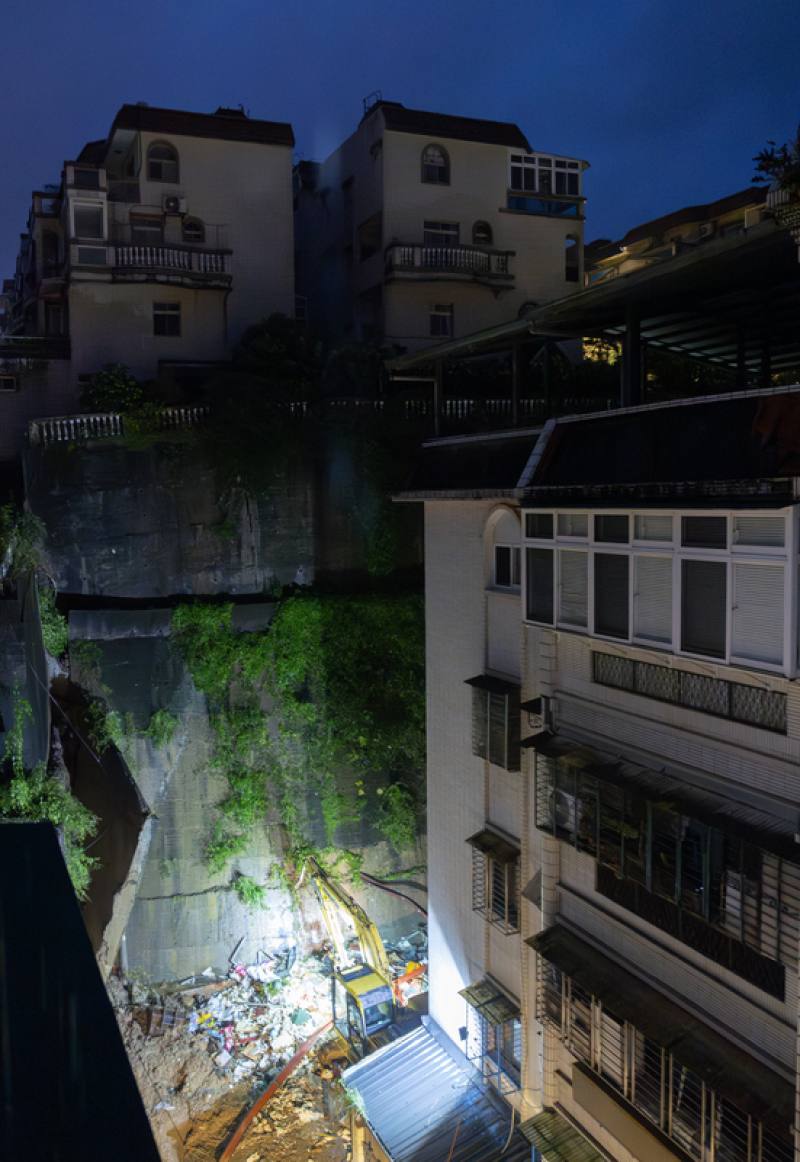 新北市新店區錦秀路49巷25日上午發生擋土牆土石崩塌滑落，現場已立即實施封鎖管制；晚間施工人員持續以重型機具進行清理、補強作業