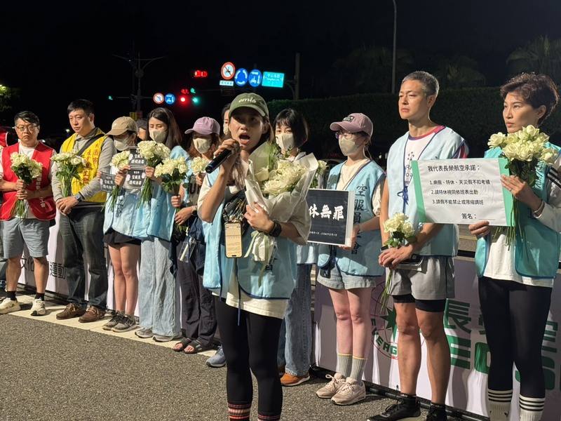 Taoyuan Flight Attendants Union board director Lin Yu-chia speaks through a microphone on behalf of her union during the protest on Sunday. CNA photo Oct. 26, 2025