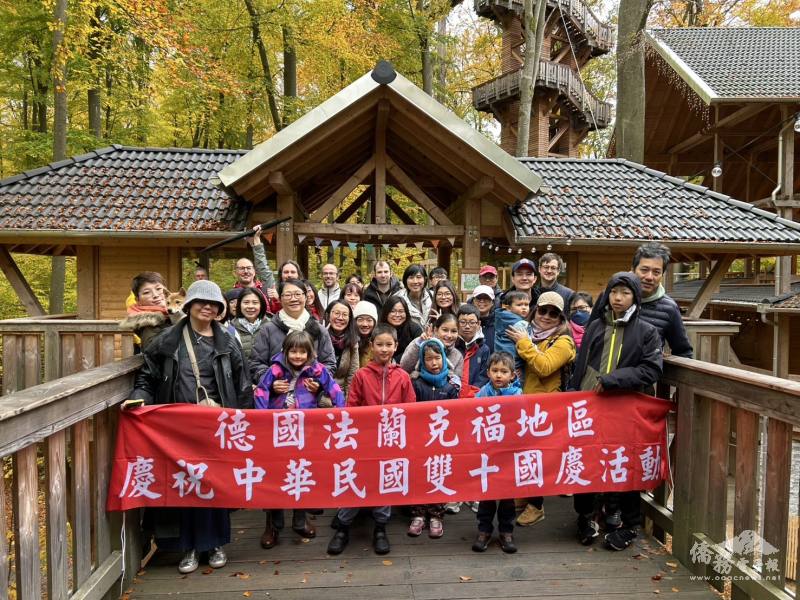 與會貴賓及僑界朋友們齊聚戶外，共同舉紅布條慶賀國慶