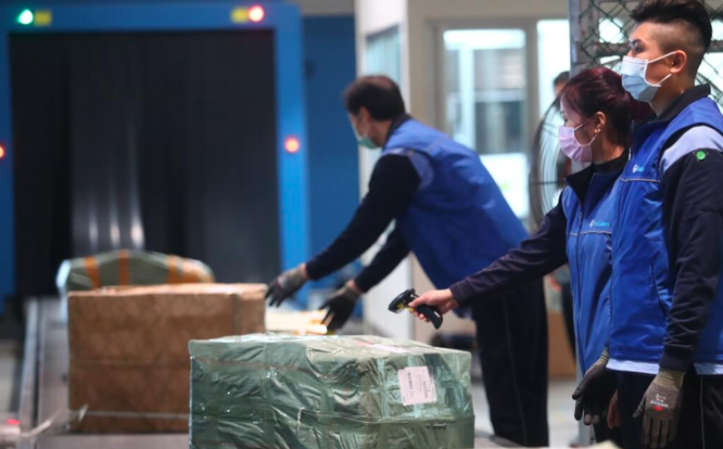 財政部關務署27日說明，不論是海空運快遞貨物或郵包，均百分之百實施X光查驗，強力防堵豬肉製品闖關。圖為港口檢疫人員在貨品輸送轉盤上檢查。（中央社檔案照片）