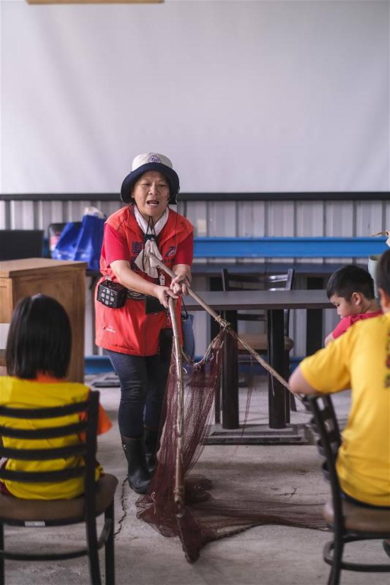 解說老師示範如何用三角網來捕魚