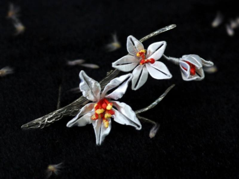 台灣領袖代表林信義小女兒林玟萱出席領袖配偶活動，並致贈具有客家文化特色的桐花銀別針（如圖）、藍衫客對杯給領袖配偶。（APEC台灣代表團提供）