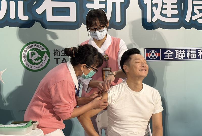 疾管署1日舉辦記者會宣布「左流右新 健康安心」進入第2階段施打，防疫大使謝祖武（右）現場挽袖接種疫苗