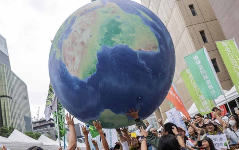 Protesters carry a giant Earth balloon high to call for environmental protection in Taipei on Saturday. CNA photo Nov. 1, 2025