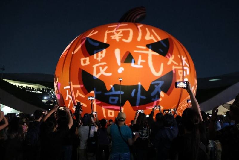 「2025高雄萬聖節」活動結合創意裝扮遊行、巨型南瓜燈光秀與各式趣味攤位，吸引全台各地遊客前來同樂，衛武營國家藝術文化中心擠滿人潮。（高雄市教育局提供）