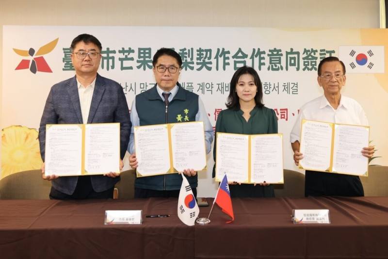 台南市楠西福農果菜運銷、信宣國際及韓國ESG農業株式會社，4日簽署契作合作意向書，預定2026年供應台南愛文芒果與金鑽鳳梨各100公噸進韓國市場，市長黃偉哲（左2）出席見證。（台南市政府提供）
