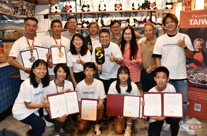 得獎選手持總統賀電與駐邁阿密辦事處處長周啟宇(第2排右4)合影