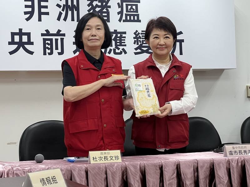 非洲豬瘟中央前進應變所6日舉行最後一場記者會，農業部次長杜文珍（左）送台南市越光米給台中市長盧秀燕（右），意喻病毒「清光光」