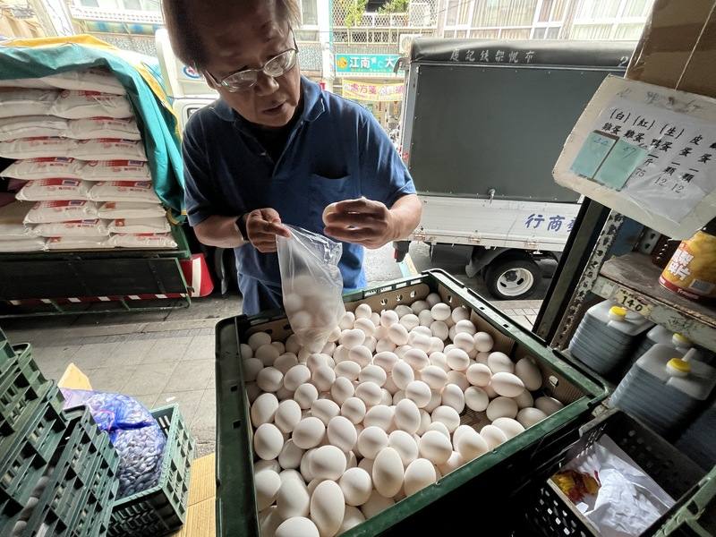 A customer selects eggs at a traditional grain and produce shop in Taipei’s Beitou District on Monday. CNA photo Nov. 10, 2025