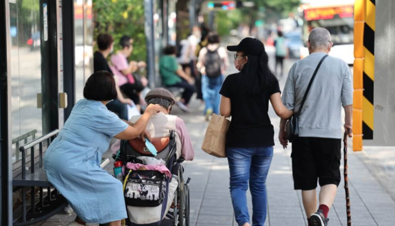 圖為台北市中正區街頭看護與受照顧長者一同外出。（中央社檔案照片）