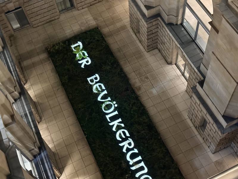 德國國會大廈中庭設有大型裝置藝術「獻給人民」（Der Bevölkerung），由藝術家漢斯．哈克（Hans Haacke）創作。各國會議員自選區帶來泥土倒入花圃中，象徵民主制度的多元與共榮，也提醒政治權力應屬於人民。