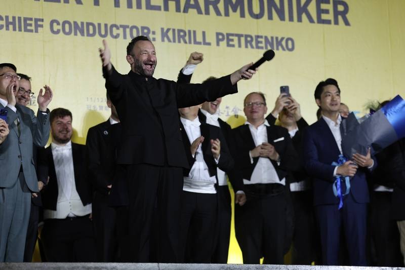 柏林愛樂首席指揮基里爾．佩特連科（Kirill Petrenko）（前左）13日晚間在台北國家音樂廳領軍演出結束後，特別現身兩廳院戶外廣場的同步轉播現場，向所有冒雨前來的樂迷致意