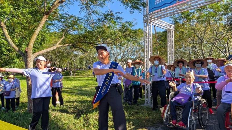 弘道老人福利基金會屏東服務處15日在屏東潮州鎮舉辦千人健走活動，「獨腳愛玩客」邱吉興（前左2）擔任大使帶領暖身操，號召民眾無懼身體狀況勇敢走出來。（弘道老人福利基金會提供）